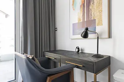 a desk with a lamp and a chair in a room at VayK - Luxurious 2BR on the Palm with Private Beach Access in Dubai