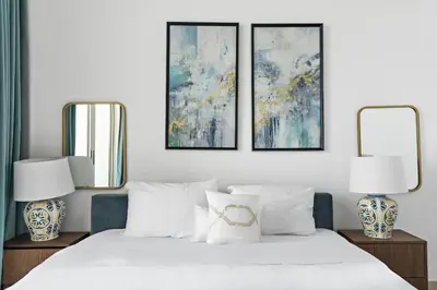 a bedroom with a white bed with three pictures on the wall at VayK - Luxurious 2BR on the Palm with Private Beach Access in Dubai