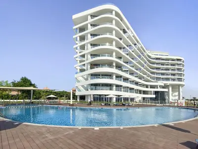 a large building with a swimming pool in front of it at VayK - Luxurious 2BR on the Palm with Private Beach Access in Dubai