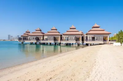 a row of buildings on a beach next to the water at VayK - Luxurious 2BR on the Palm with Private Beach Access in Dubai