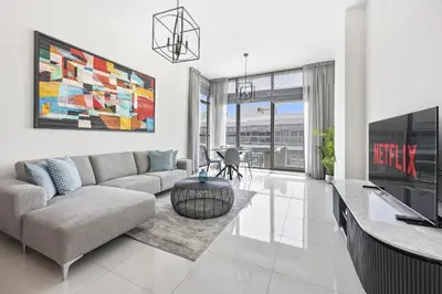 a living room with a couch and a tv at VayK - Great 1BR Apartment in Damac Hills in Dubai