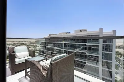 a balcony with chairs and a view of a building at VayK - Great 1BR Apartment in Damac Hills in Dubai