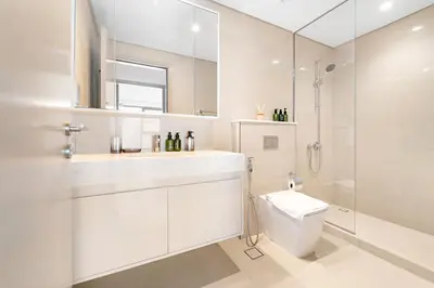 a white bathroom with a toilet and a shower at VayK - Stylish 1BR in Iconic Downtown Location in Dubai