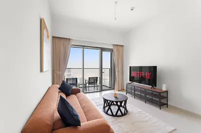 a living room with a couch and a tv at VayK - Stylish 1BR in Iconic Downtown Location in Dubai