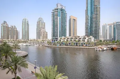 a city with tall buildings and a river with boats at Vayk - Bright and Spacious 2BR with Panoramic Marina Views in Dubai