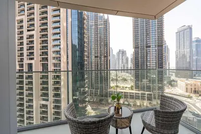 a balcony with chairs and a table with a view of a city at PVH - Elegant 2BR near Dubai Mall - Opera Grand in Dubai