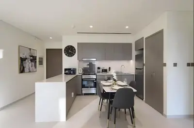 a kitchen and dining room with a table and chairs at Luxury Grande Signature Apartment in Dubai Downtown Steps to Dubai Mall and Burj Khalifa with Stunning Pool View by La Brisa Dubai in Dubai