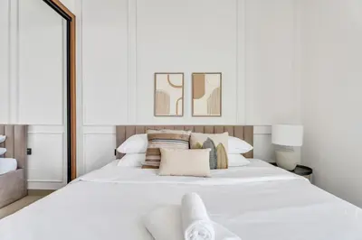 a white bedroom with a large white bed with pillows at GuestReady - High floor Luxury with a Private Pool in Dubai