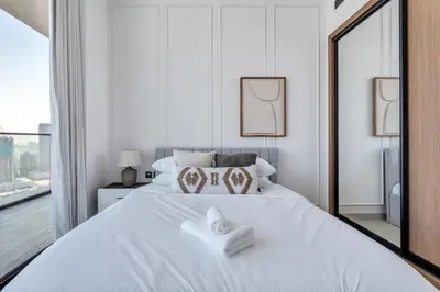 a white bedroom with a large bed with towels on it at GuestReady - High floor Luxury with a Private Pool in Dubai