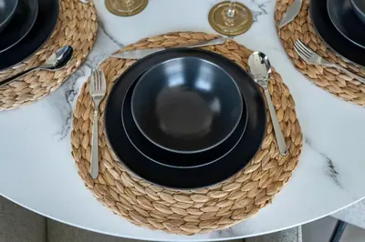 a table with black plates and utensils on a table at GuestReady - High floor Luxury with a Private Pool in Dubai