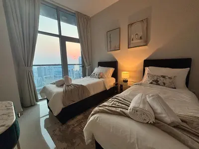 two beds in a room with a large window at Marina Sunset Haven - Breathtaking Views in Dubai