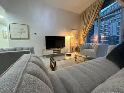 a living room with a couch and a flat screen tv at Marina Sunset Haven - Breathtaking Views in Dubai
