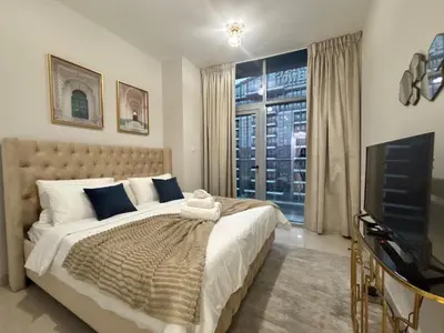 a bedroom with a large bed and a television at Marina Sunset Haven - Breathtaking Views in Dubai