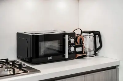 a microwave sitting on top of a kitchen counter at Inspiring 1BR Apartment at Sobha Hartland in Dubai