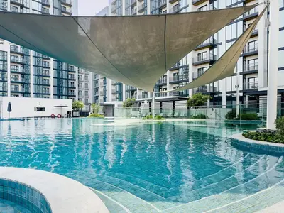 a swimming pool in a city with tall buildings at Inspiring 1BR Apartment at Sobha Hartland in Dubai