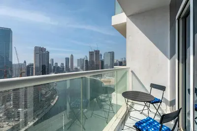 a balcony with a table and chairs on a building at GuestReady - Damac Prive | 1BR Canal View in Dubai