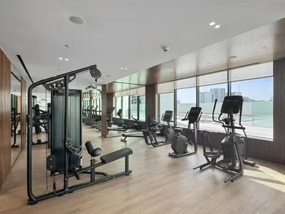 a gym with a bunch of exercise equipment in a building at Cozy 1 Bedroom in JVC with Stunning City Views in Dubai