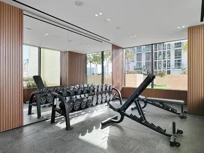 a gym with a row of treadmills and machines at Cozy 1 Bedroom in JVC with Stunning City Views in Dubai