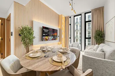 a living room with a table and chairs at Cozy 1 Bedroom in JVC with Stunning City Views in Dubai