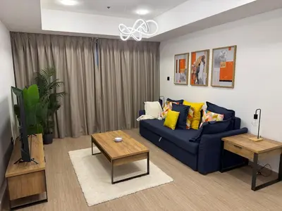 a living room with a blue couch and a table at Full Luxury 2 Bedrooms Apartment, Princess Tower in Dubai