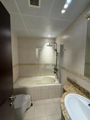 a bathroom with a tub and a toilet and a sink at Full Luxury 2 Bedrooms Apartment, Princess Tower in Dubai