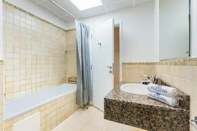 a bathroom with a sink and a bath tub and a bath tub at Central JBR Home Steps away from the Beach in Dubai