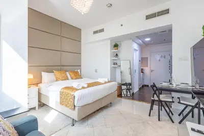 a bedroom with a large bed and a desk at Park Central, Business Bay - Studio Apartment - Allsopp & Allsopp in Dubai