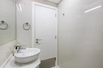 a white bathroom with a sink and a shower at Park Central, Business Bay - Studio Apartment - Allsopp & Allsopp in Dubai