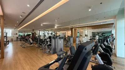 a gym with many treadmills and people exercising in it at Huge Modern 1BR in Creek Harbour steps to Central Park with a creek view and infinity pool by La Brisa Dubai in Dubai