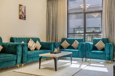 a living room with two blue couches and a table at 1BR Poolside Serenity in JVT in Dubai