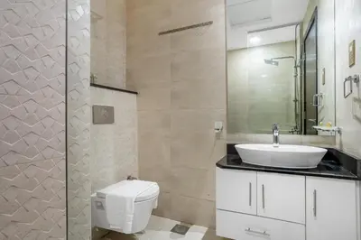 a bathroom with a white toilet and a sink at 1BR Poolside Serenity in JVT in Dubai