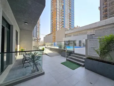 a balcony of a building with stairs and plants at 1BR Poolside Serenity in JVT in Dubai