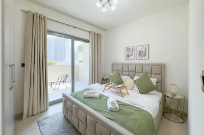 a bedroom with a large bed and a balcony at 1 Bedroom Apt in Sobha Creek Vistas Tower B by Luxaura in Dubai