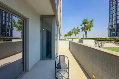 a balcony with a chair on the side of a building at 1 Bedroom Apt in Sobha Creek Vistas Tower B by Luxaura in Dubai