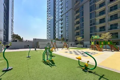 a playground with play equipment on the grass in a city at 1 Bedroom Apt in Sobha Creek Vistas Tower B by Luxaura in Dubai