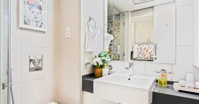 a white bathroom with a sink and a mirror at Luxury Studio on Palm Jumeirah Beach Access in Dubai