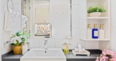 a white bathroom with a sink and a mirror at Luxury Studio on Palm Jumeirah Beach Access in Dubai