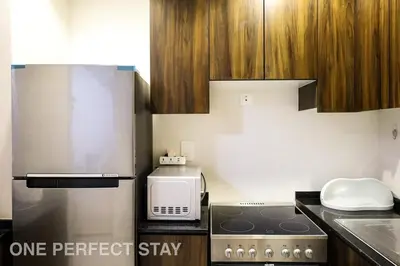 a kitchen with a stove and a microwave at Elegant 3BR Villa - Peaceful - Family Friendly in Dubai
