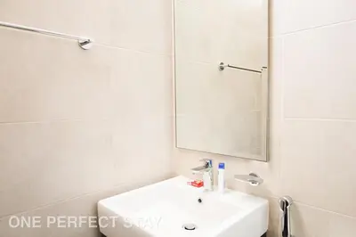 a white bathroom with a sink and a mirror at Elegant 3BR Villa - Peaceful - Family Friendly in Dubai