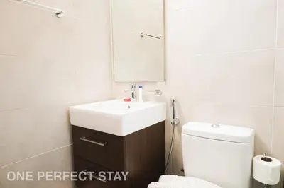 a bathroom with a sink and a toilet and a mirror at Elegant 3BR Villa - Peaceful - Family Friendly in Dubai