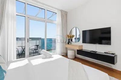 a bedroom with a large bed and a large window at High-Floor Studio, Walking Distance to the Park and 15-Min Drive to Miracle Garden, Al Jawhara Tower, Jumeirah Village Triangle by Deluxe Holiday Homes in Dubai