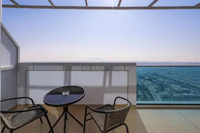 a table and two chairs in a room with a view at High-Floor Studio, Walking Distance to the Park and 15-Min Drive to Miracle Garden, Al Jawhara Tower, Jumeirah Village Triangle by Deluxe Holiday Homes in Dubai