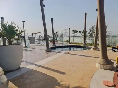 a swimming pool in a park with a potted plant at High-Floor Studio, Walking Distance to the Park and 15-Min Drive to Miracle Garden, Al Jawhara Tower, Jumeirah Village Triangle by Deluxe Holiday Homes in Dubai