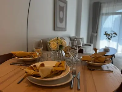 a wooden table with plates and wine glasses on it at Luxury 1BR in Madinat Jumeirah Living in Dubai