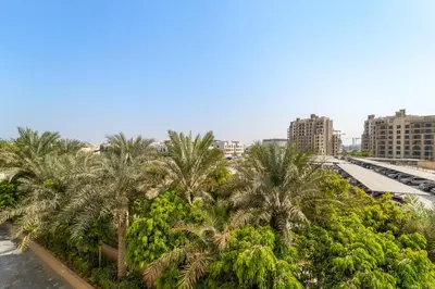 a group of palm trees in a city at Luxury 1BR in Madinat Jumeirah Living in Dubai
