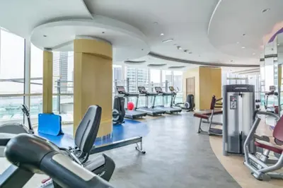 a gym with a lot of treadmills and ellipticals at Elegant 1-Bedroom Apartment at Downtown Dubai with Stunning Canal & Skyline Views in Dubai