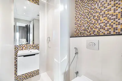 a bathroom with a toilet and a sink and a mirror at Elegant 1-Bedroom Apartment at Downtown Dubai with Stunning Canal & Skyline Views in Dubai