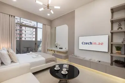 a bedroom with a bed and a tv on a wall at Elegant Studio Escape in JVC - by Czechin in Dubai