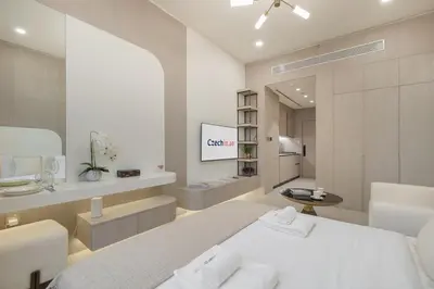 a white bedroom with a bed and a mirror at Elegant Studio Escape in JVC - by Czechin in Dubai