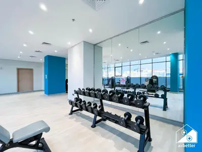 a gym with a row of dumbbells and mirrors at Premium Riviera Studio King Bed, Pool & Gym in Dubai